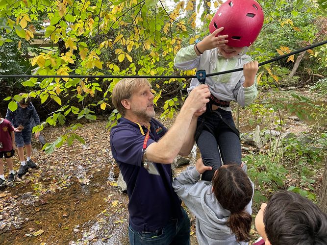 Instructor helping child on zipline