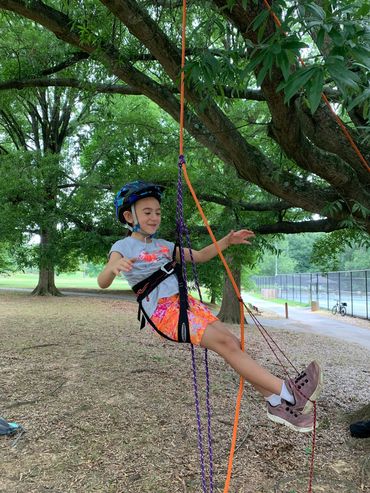 Child on rope swing in park